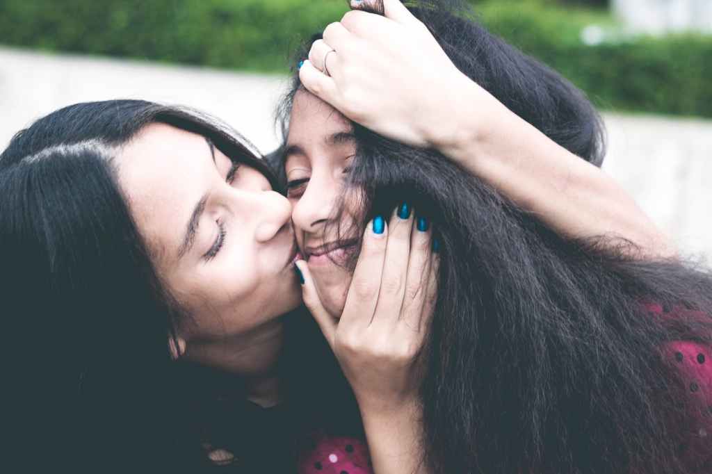 mother kissing daughter 