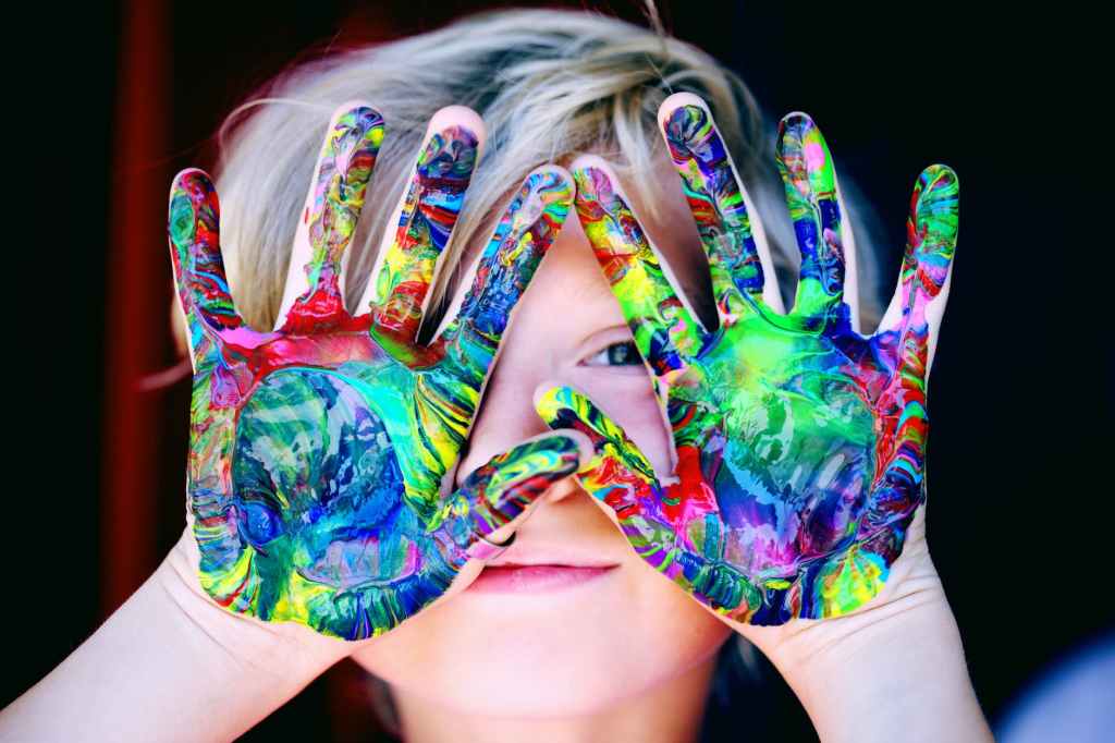 child with colourful hands