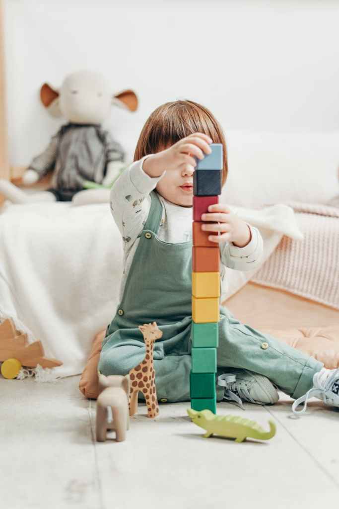 child building brick tower - fun activity to promote counting skills