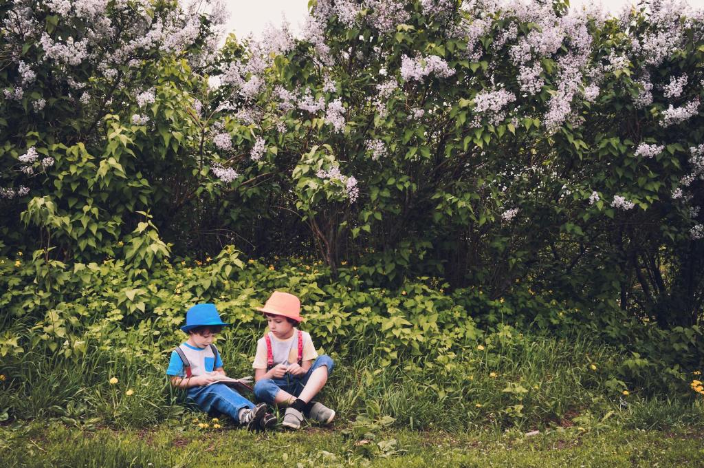 Girl and boy sitting outside in nature